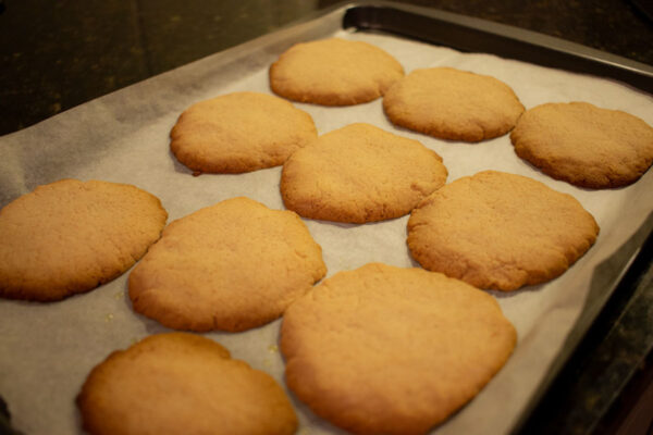 A tray of cooked gingernut biscuits in the oven