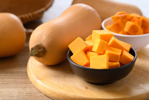 Cubed butternut squash in a bowl on wooden board preparing for cooking