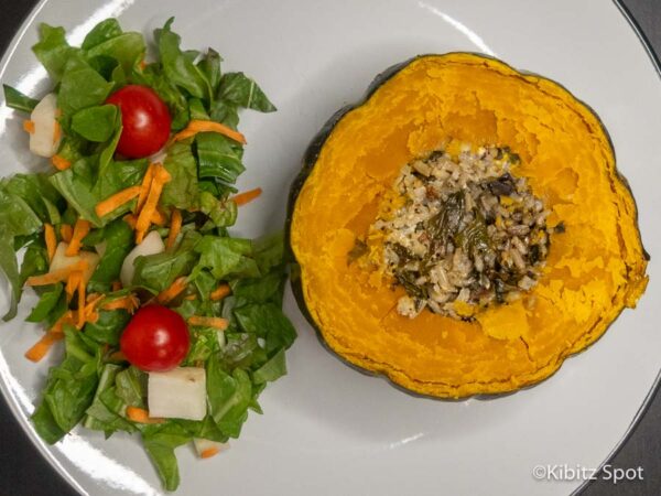 Stuffed kabacha squash served with a side salad on a plate. 