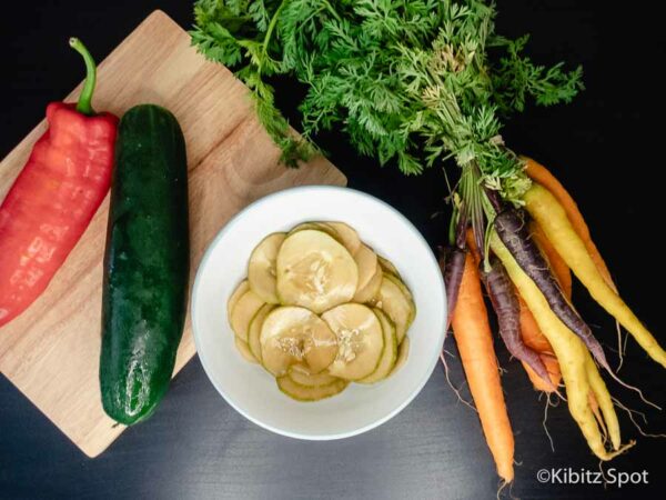 Ready to serve marinated cucumber, with carrots and pepper on the side.