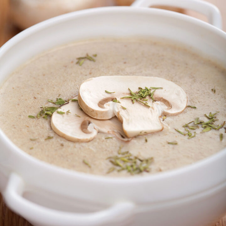 A bowl of creamy mushroom and walnut soup with mushroom slices floating on top