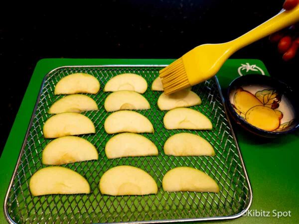 Brushing avocado oil on apple wedges.