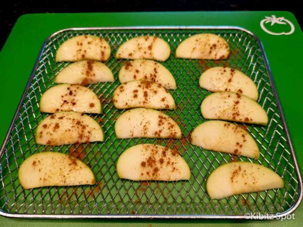 A tray of apple wedges, with a thin layer of oil and cinnamon