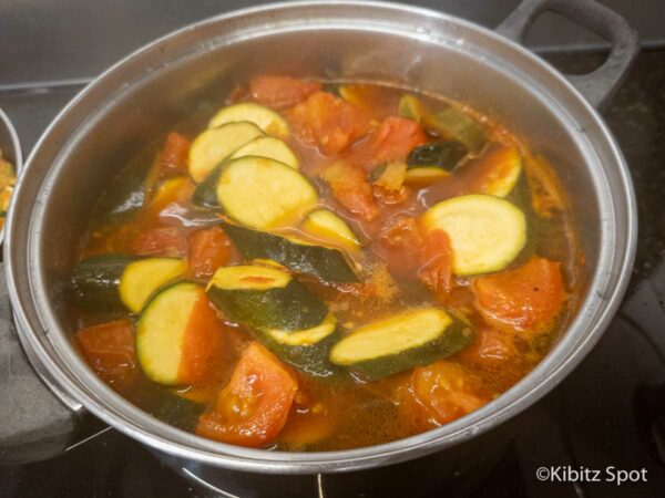 Vietnamese zucchini and tomatoes in a saucepan, steaming and ready to serve.