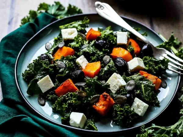 Kale salad on a plate with pumpkin and keta