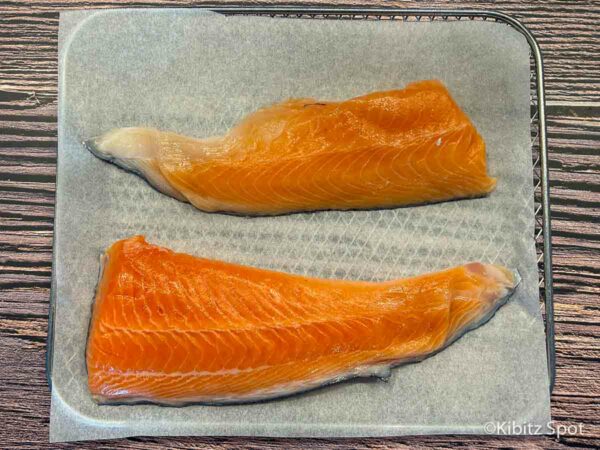 Raw salmon on parchment paper ready to go into the air fryer